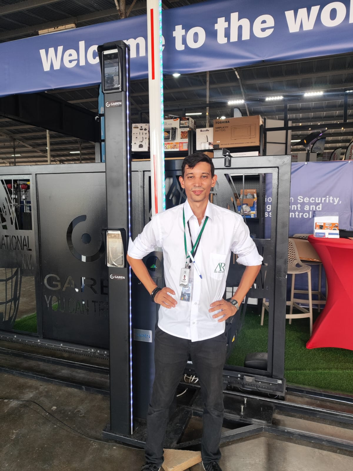 Técnico ARIA Solutions em Estande Oficial com painel GAREN